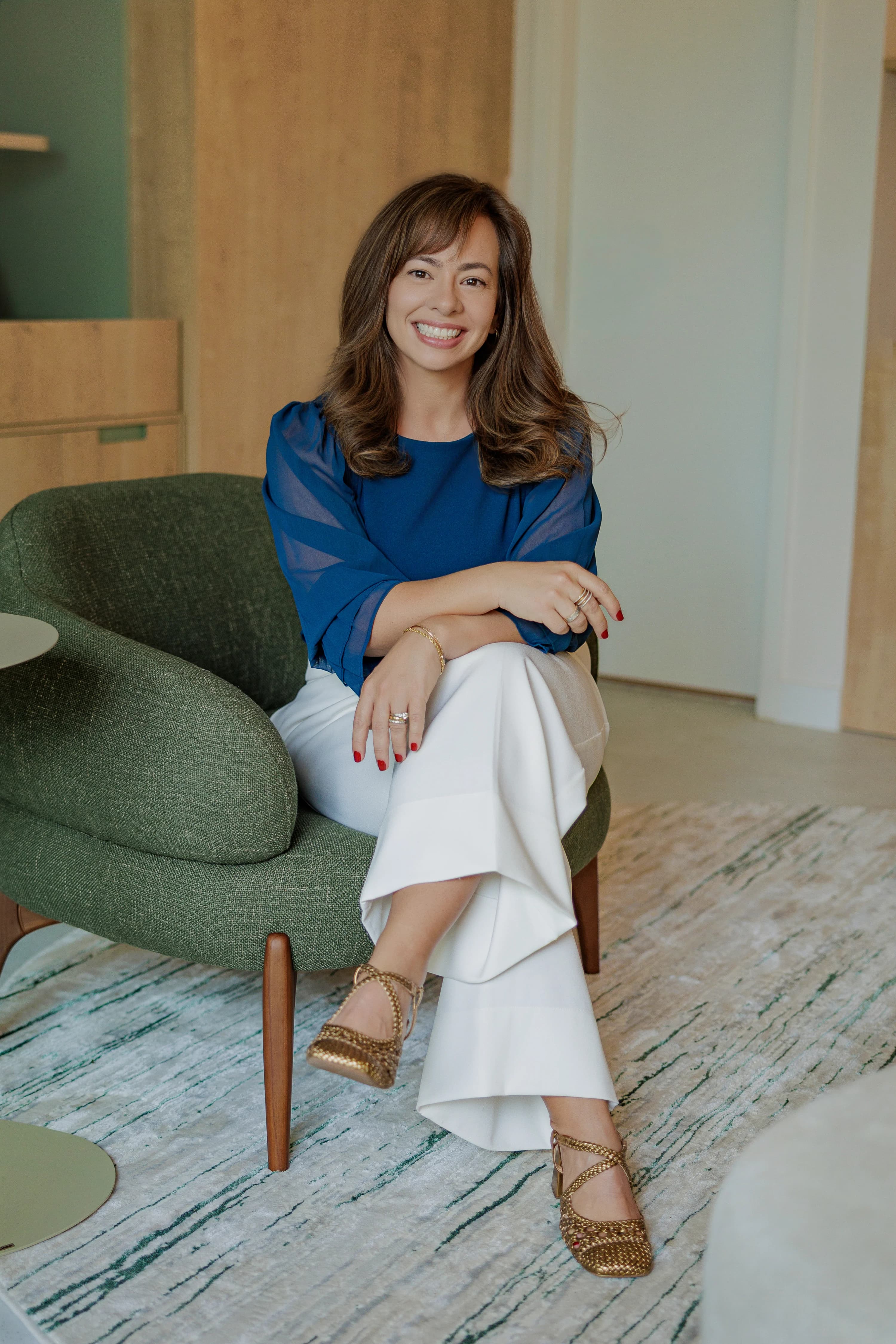 Psicóloga Camila Mazzanti em poltrona verde.