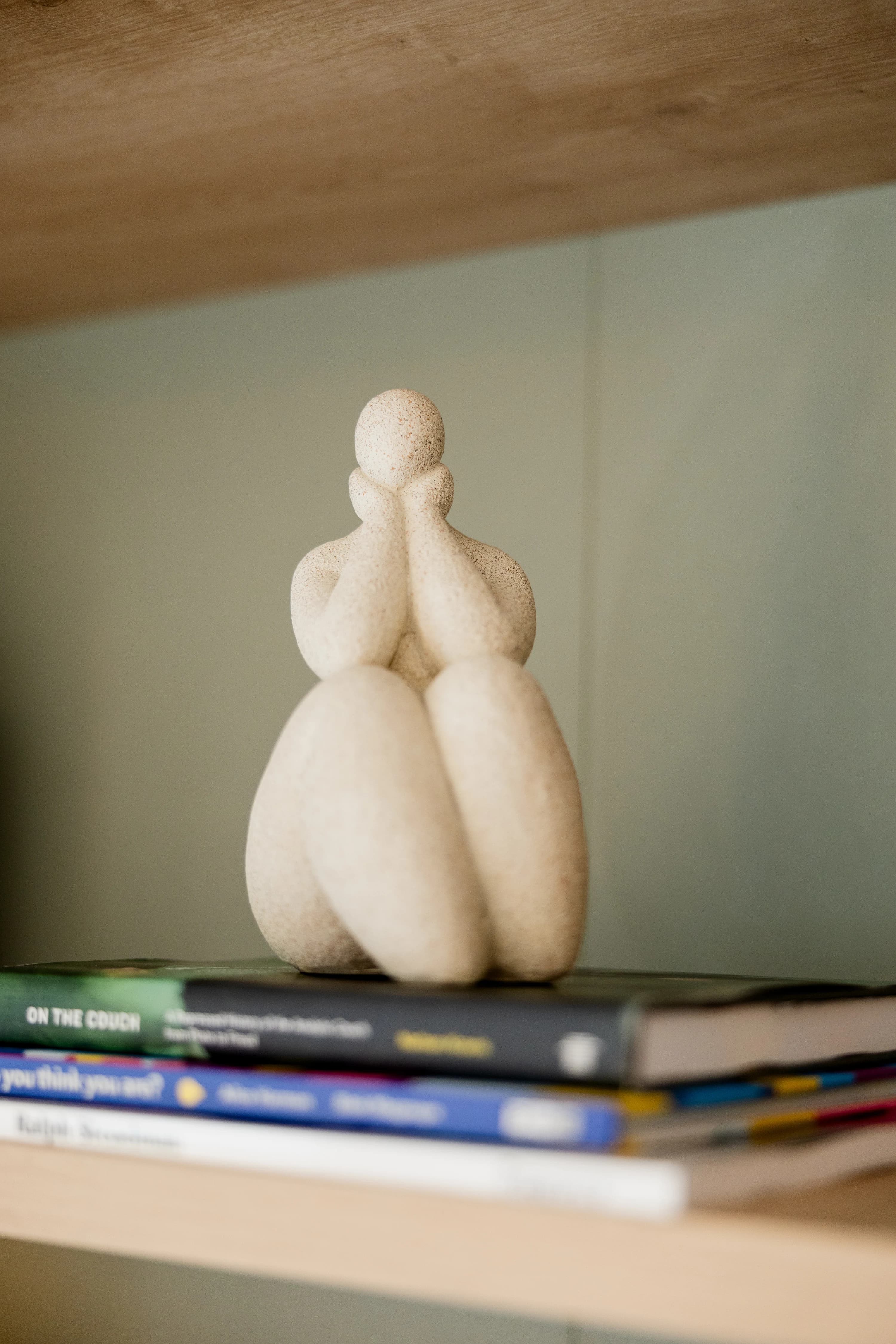 Escultura minimalista branca e livros de psicologia simbolizando reflexão terapêutica
